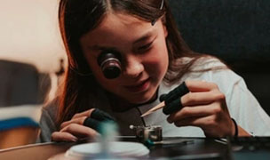 Young visitor discovering watchmaking craftsmanship at Autour du Temps in Geneva